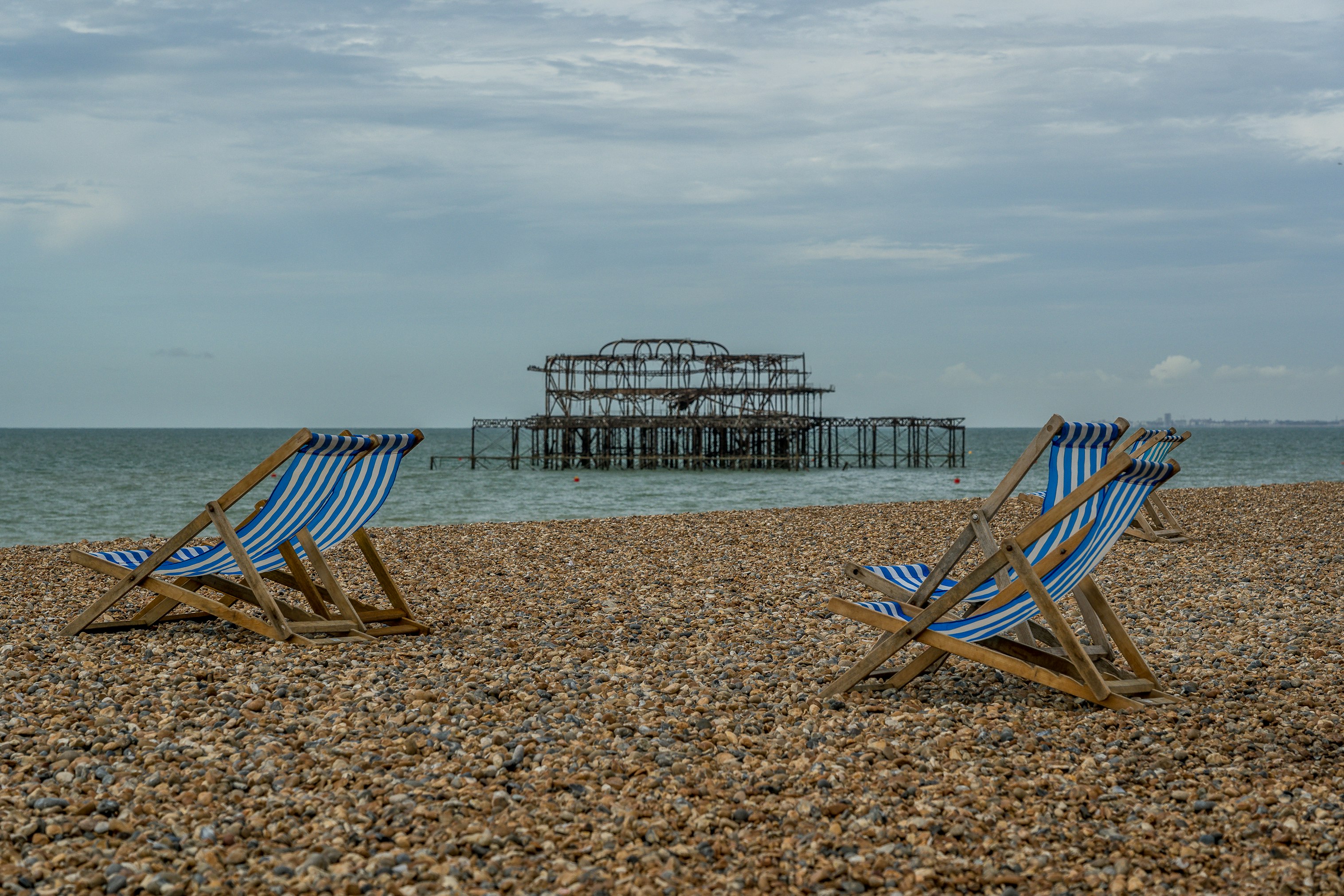 brown wooden folding chairs on beach during daytime
